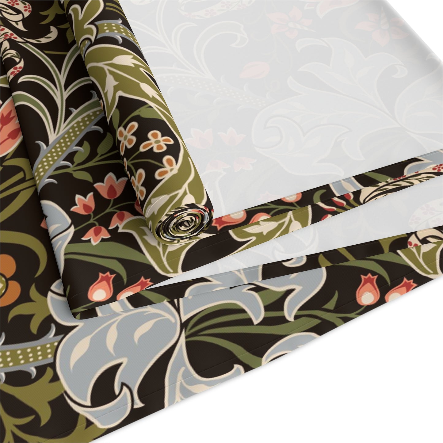 A table runner with a floral William Morris & Co pattern in shades of green, gold, and other colours, laid out on a dining table with dishes and glasses arranged on top.