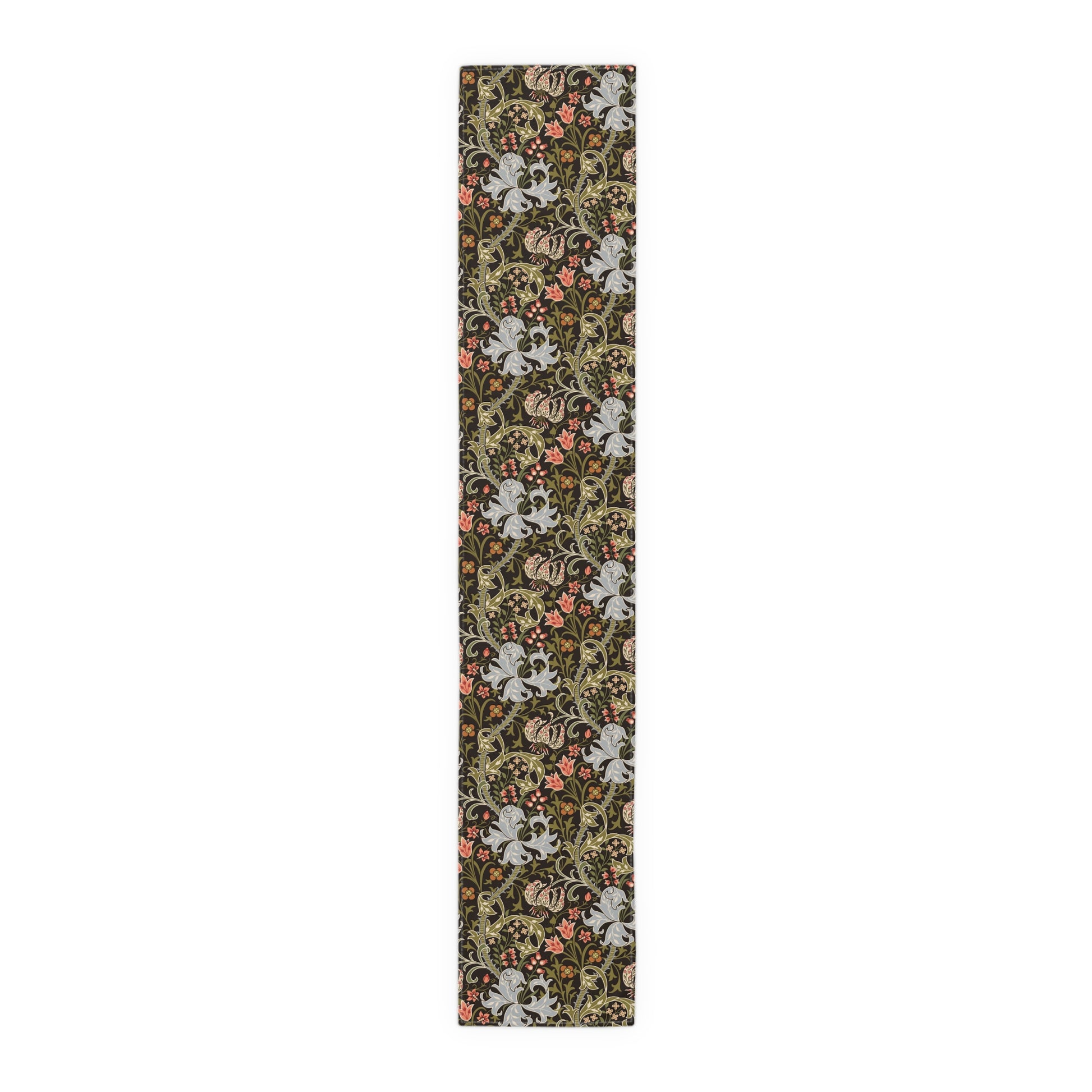 A table runner with a floral William Morris & Co pattern in shades of green, gold, and other colours, laid out on a dining table with dishes and glasses arranged on top.
