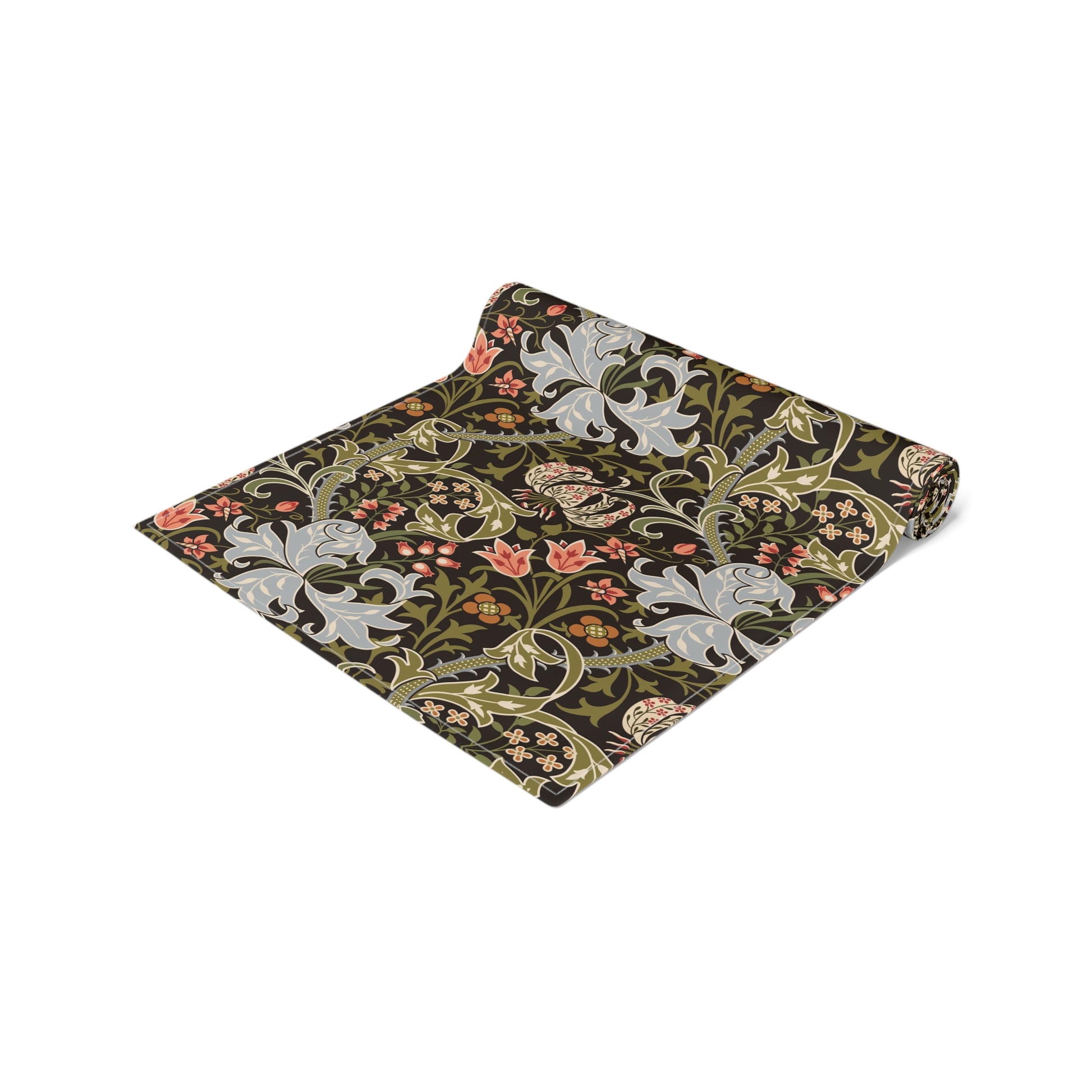 A table runner with a floral William Morris & Co pattern in shades of green, gold, and other colours, laid out on a dining table with dishes and glasses arranged on top.