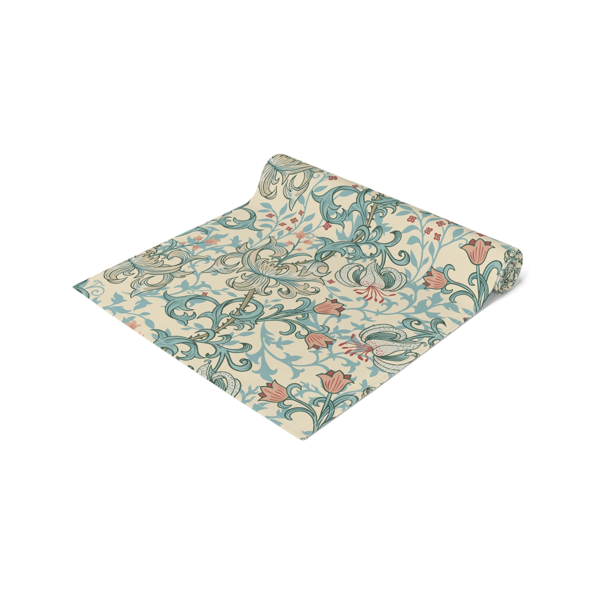 A table runner with a floral William Morris & Co pattern in green, beige, and gold colours, laid out on a dining table.
