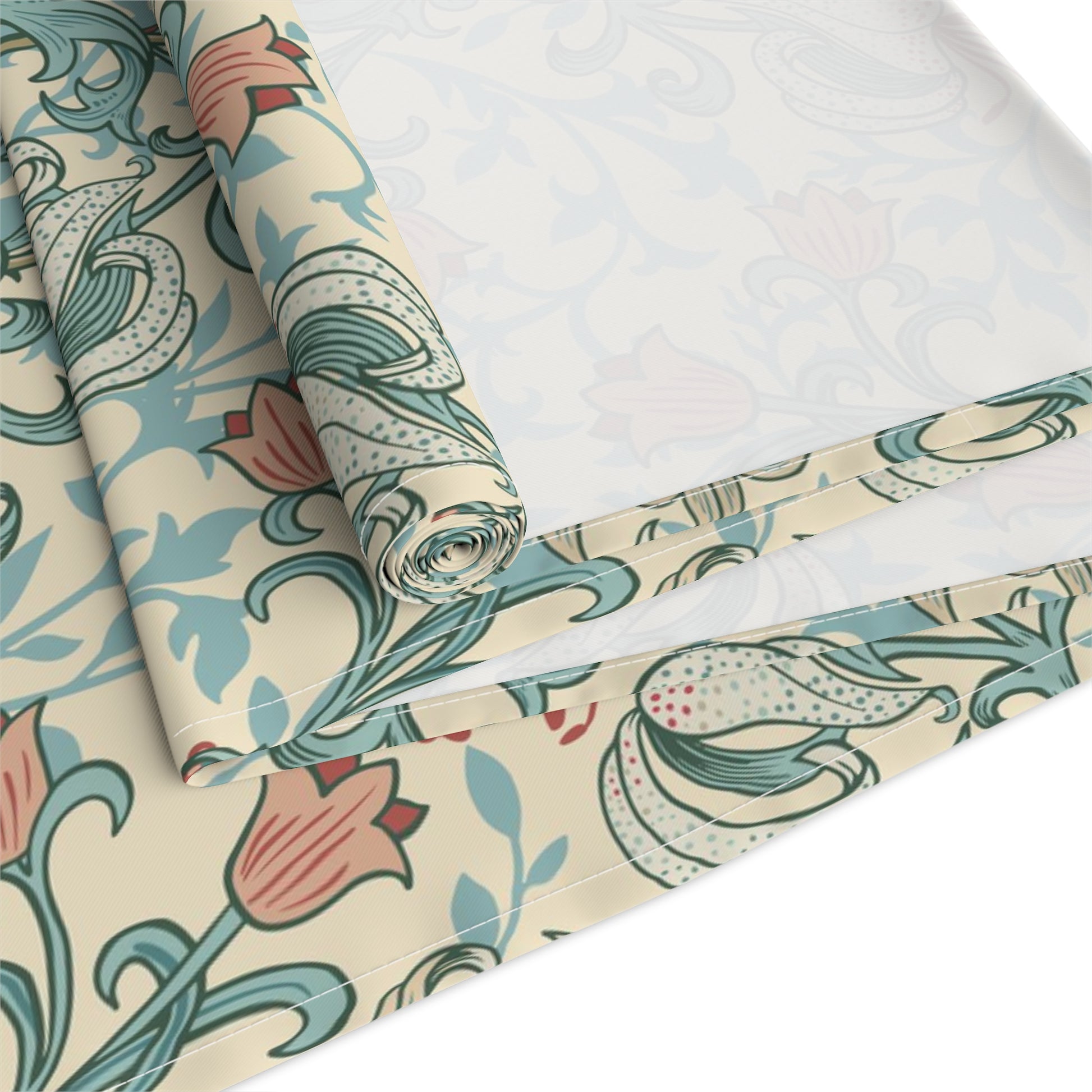 A table runner with a floral William Morris & Co pattern in green, beige, and gold colours, laid out on a dining table.