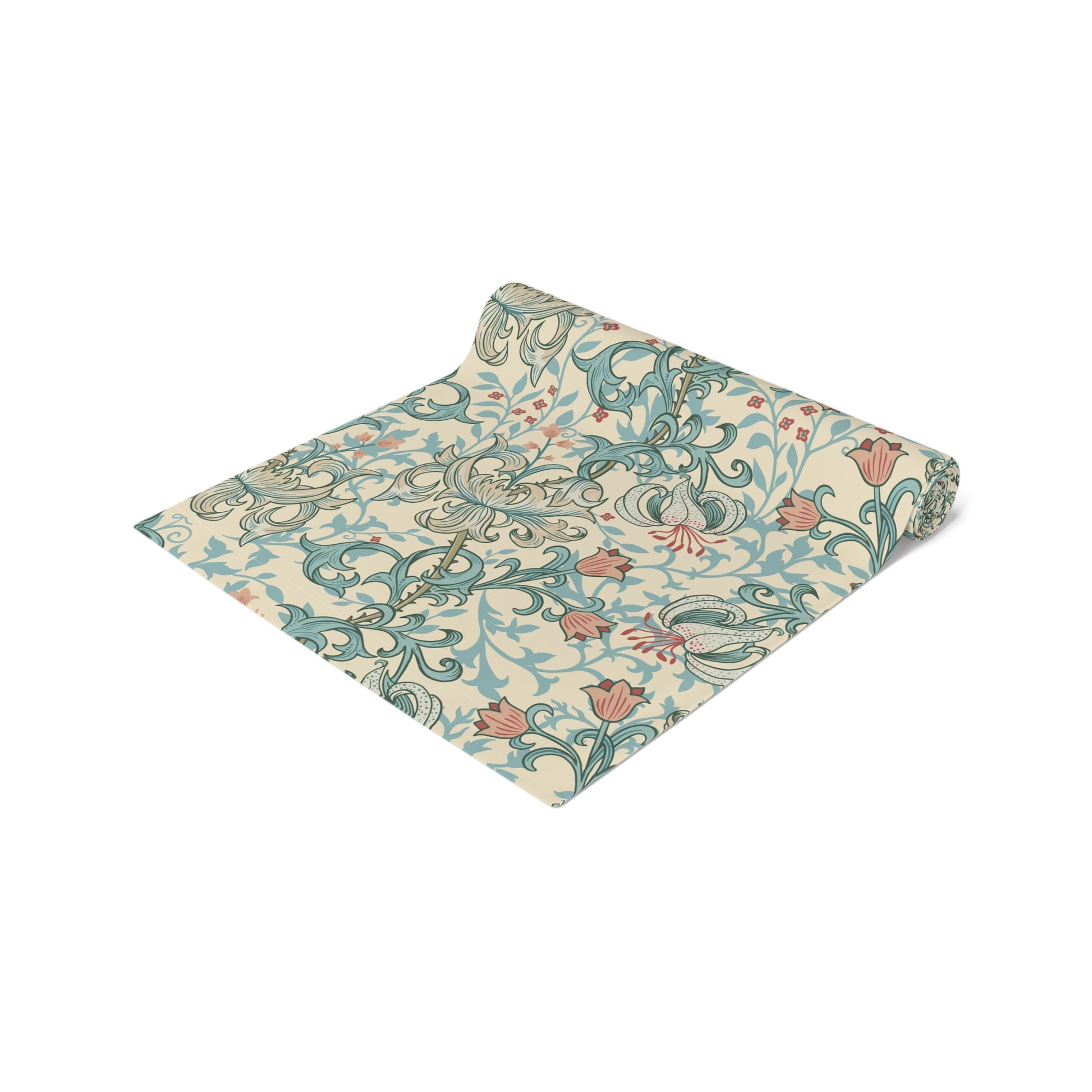 A table runner with a floral William Morris & Co pattern in green, beige, and gold colours, laid out on a dining table.