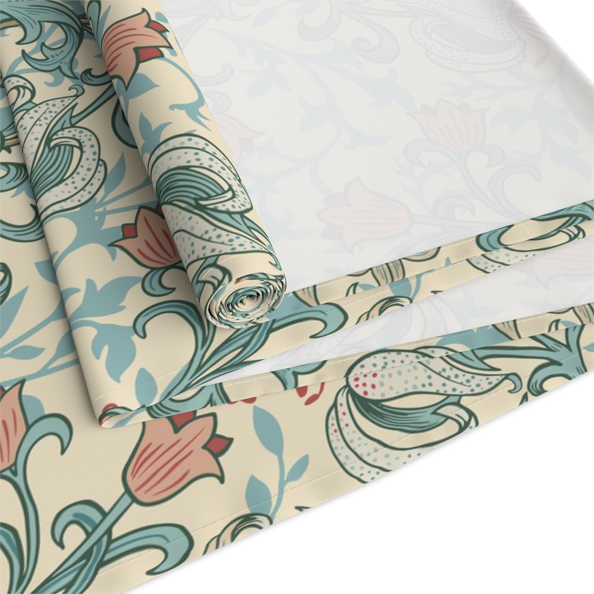 A table runner with a floral William Morris & Co pattern in green, beige, and gold colours, laid out on a dining table.