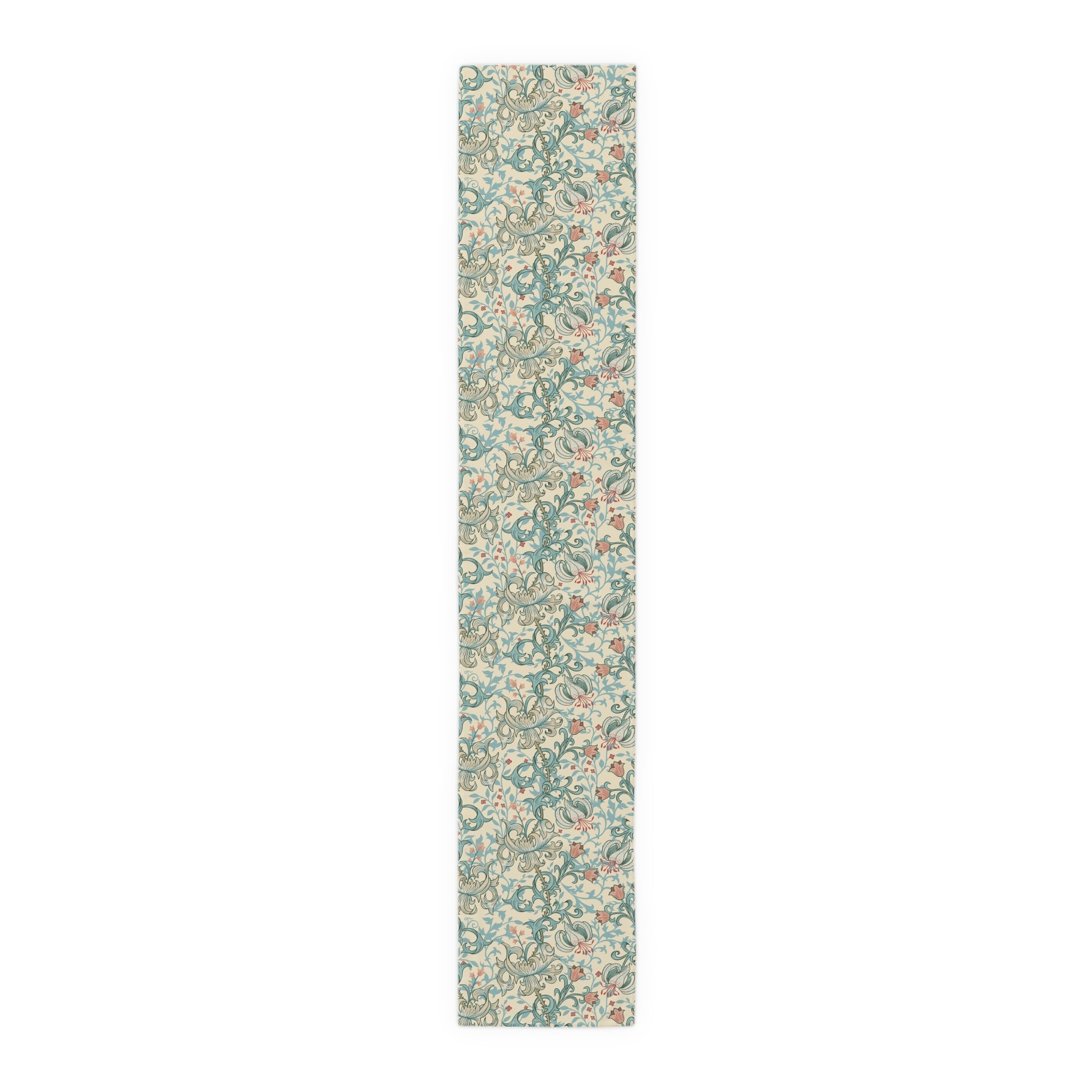 A table runner with a floral William Morris & Co pattern in green, beige, and gold colours, laid out on a dining table.
