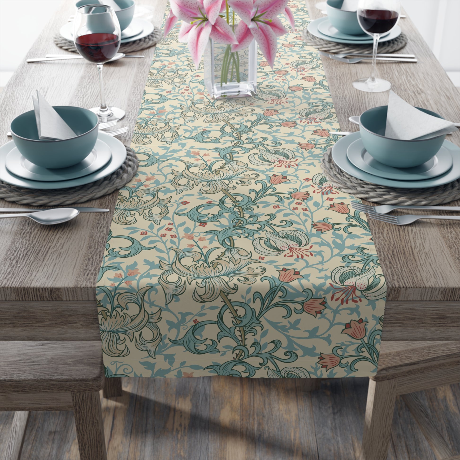 A table runner with a floral pattern in green, beige, and gold colors, laid out on a dining table.