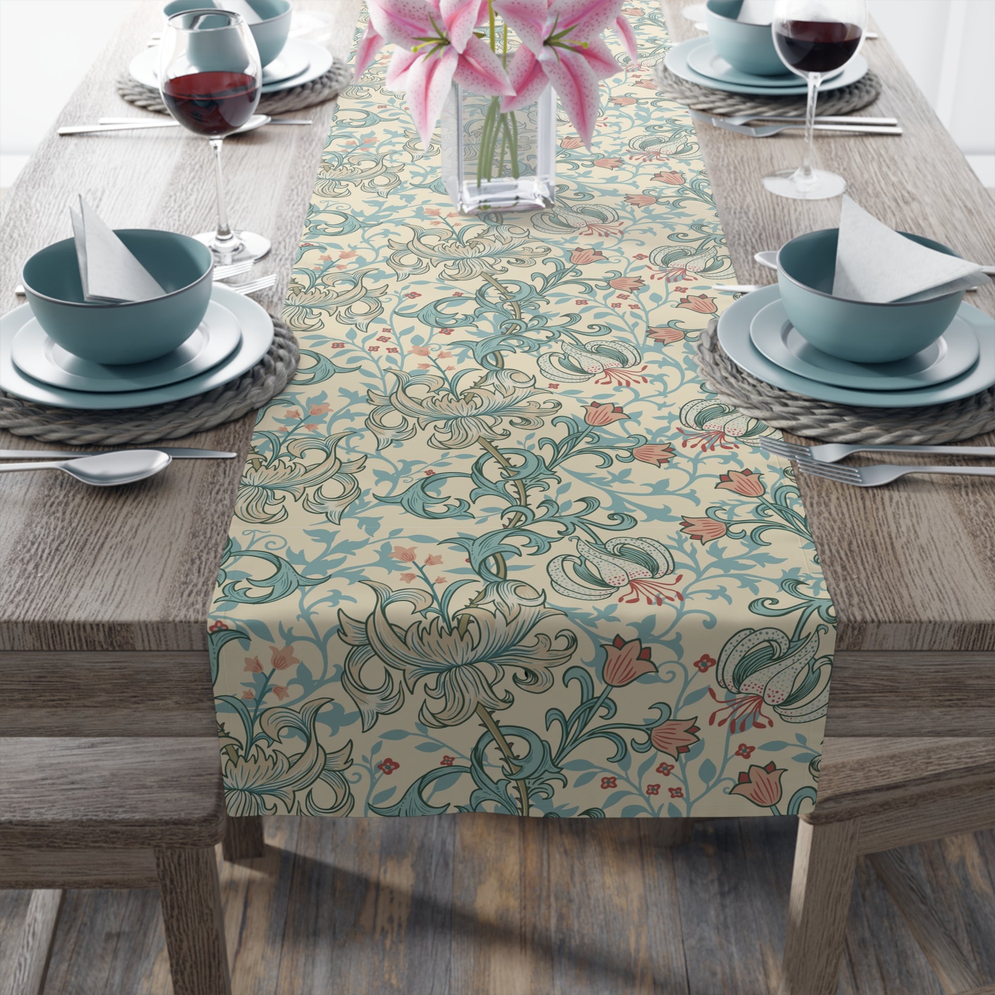 A table runner with a floral pattern in green, beige, and gold colors, laid out on a dining table.