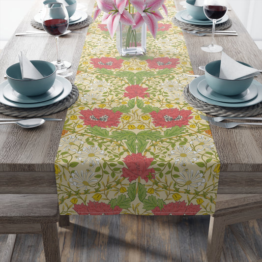 A table runner with a floral William Morris & Co pattern in red, green, and white colours, laid out on a dining table.
