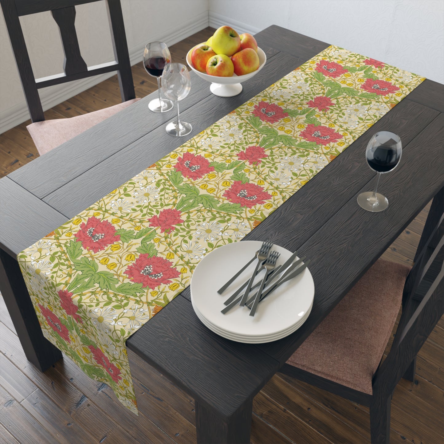 A table runner with a floral William Morris & Co pattern in red, green, and white colours, laid out on a dining table.