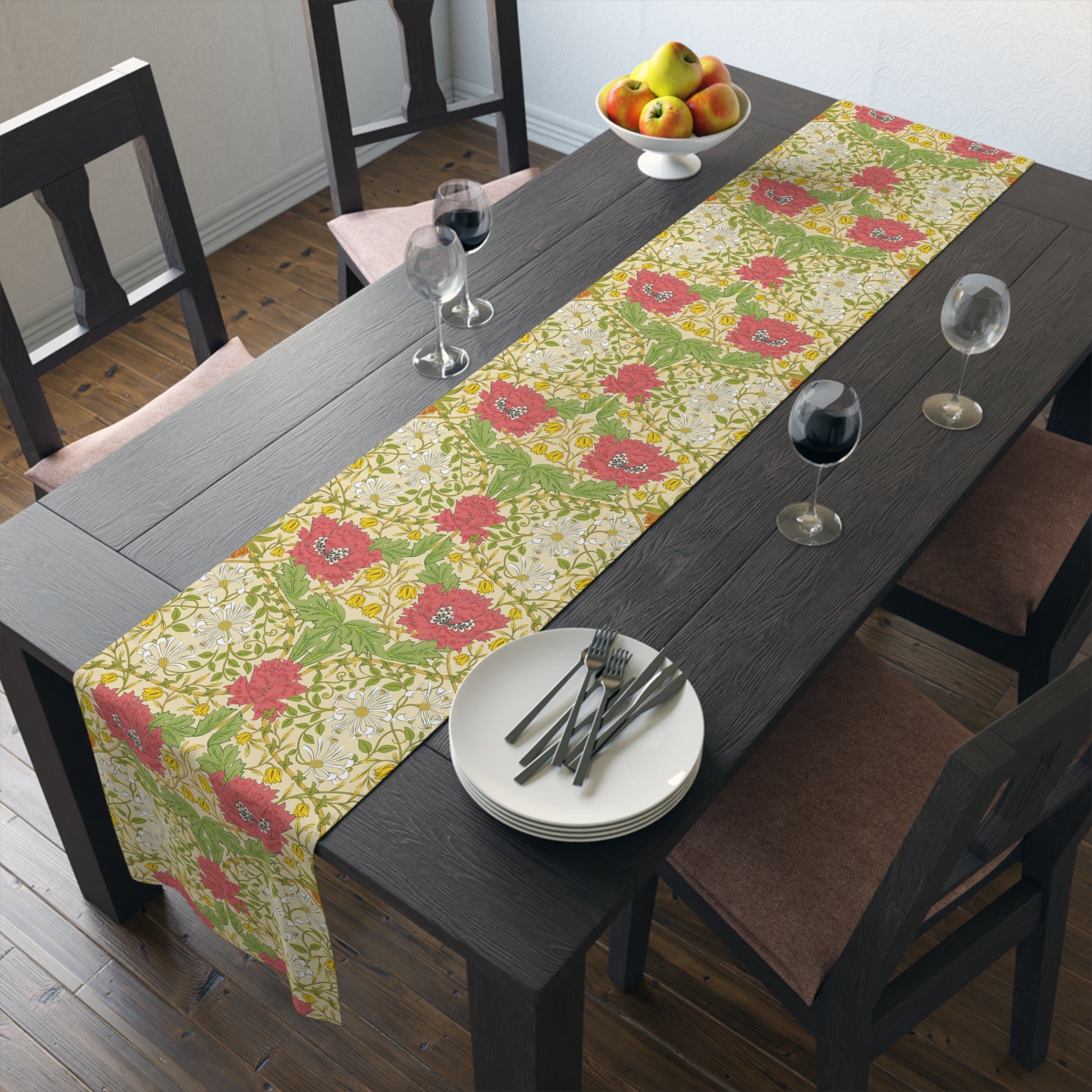 A table runner with a floral William Morris & Co pattern in red, green, and white colours, laid out on a dining table.