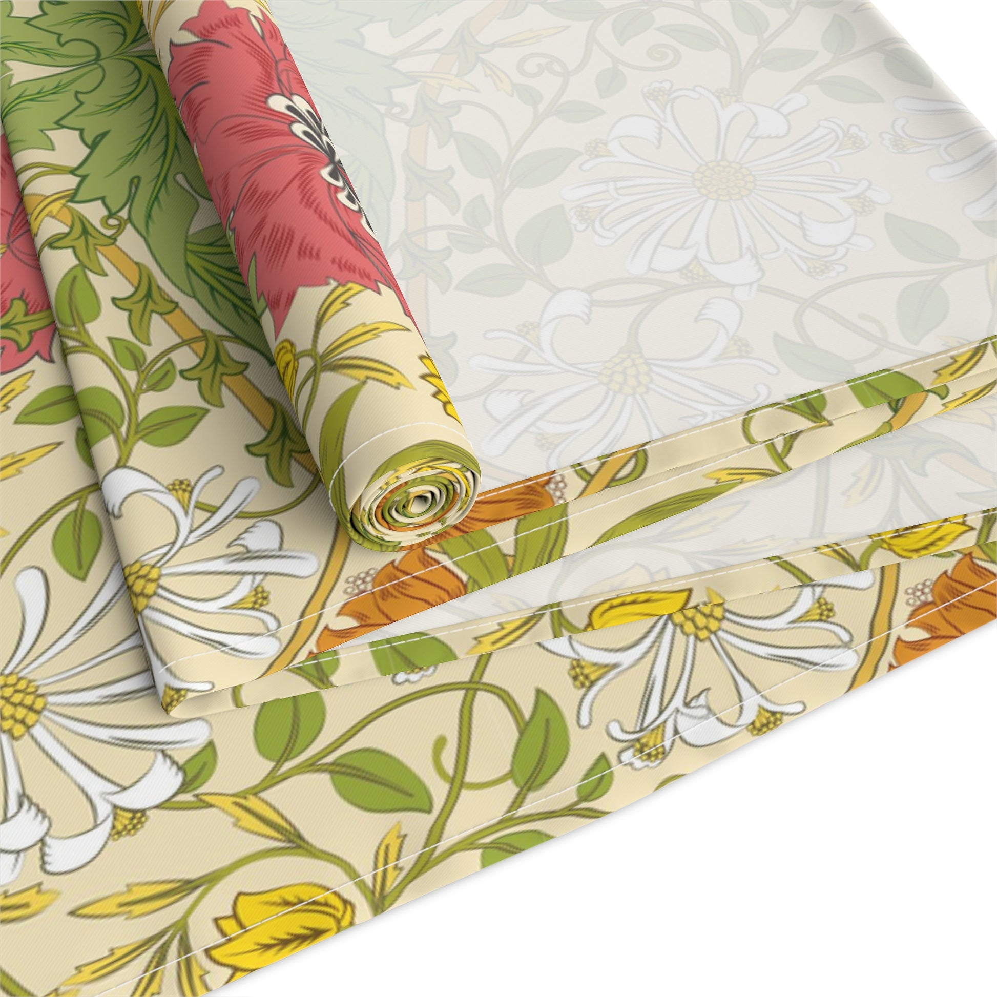 A table runner with a floral William Morris & Co pattern in red, green, and white colours, laid out on a dining table.