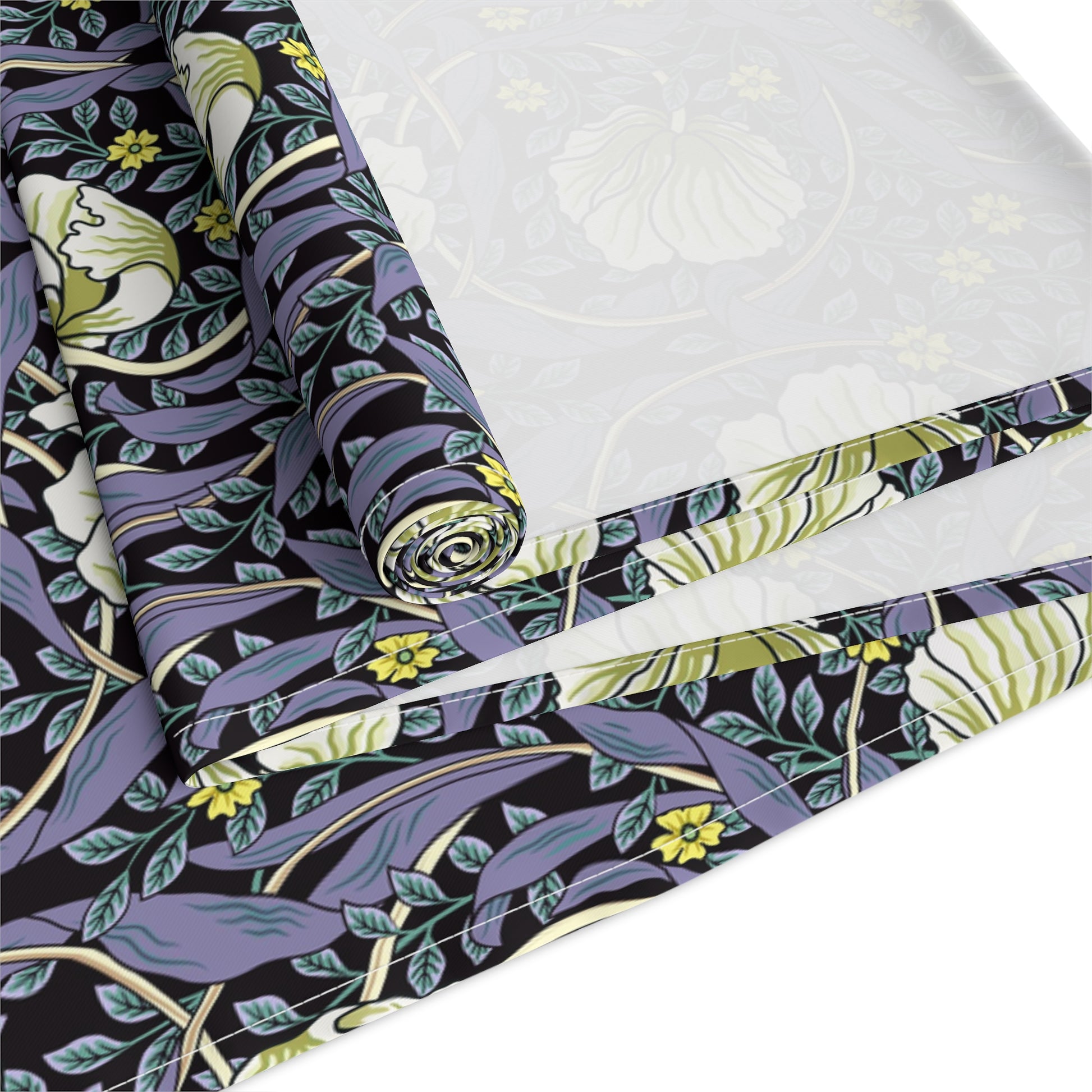 A table runner with a floral William Morris & Co pattern in shades of purple and green laid out on a dining table.