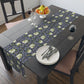 A table runner with a floral William Morris & Co pattern in shades of purple and green laid out on a dining table.