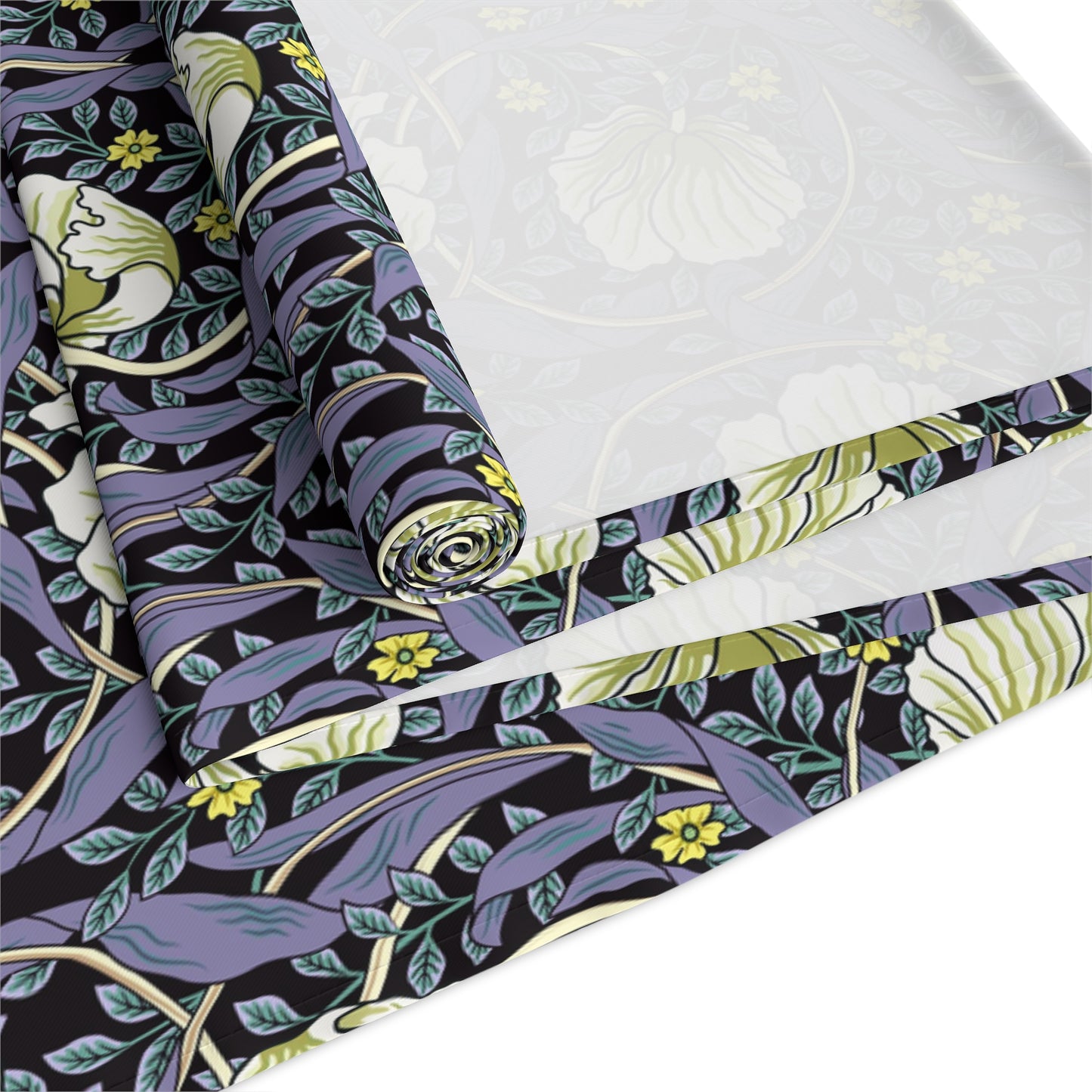 A table runner with a floral William Morris & Co pattern in shades of purple and green laid out on a dining table.