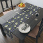A table runner with a floral William Morris & Co pattern in shades of purple and green laid out on a dining table.