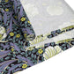 A table runner with a floral William Morris & Co pattern in shades of purple and green laid out on a dining table.
