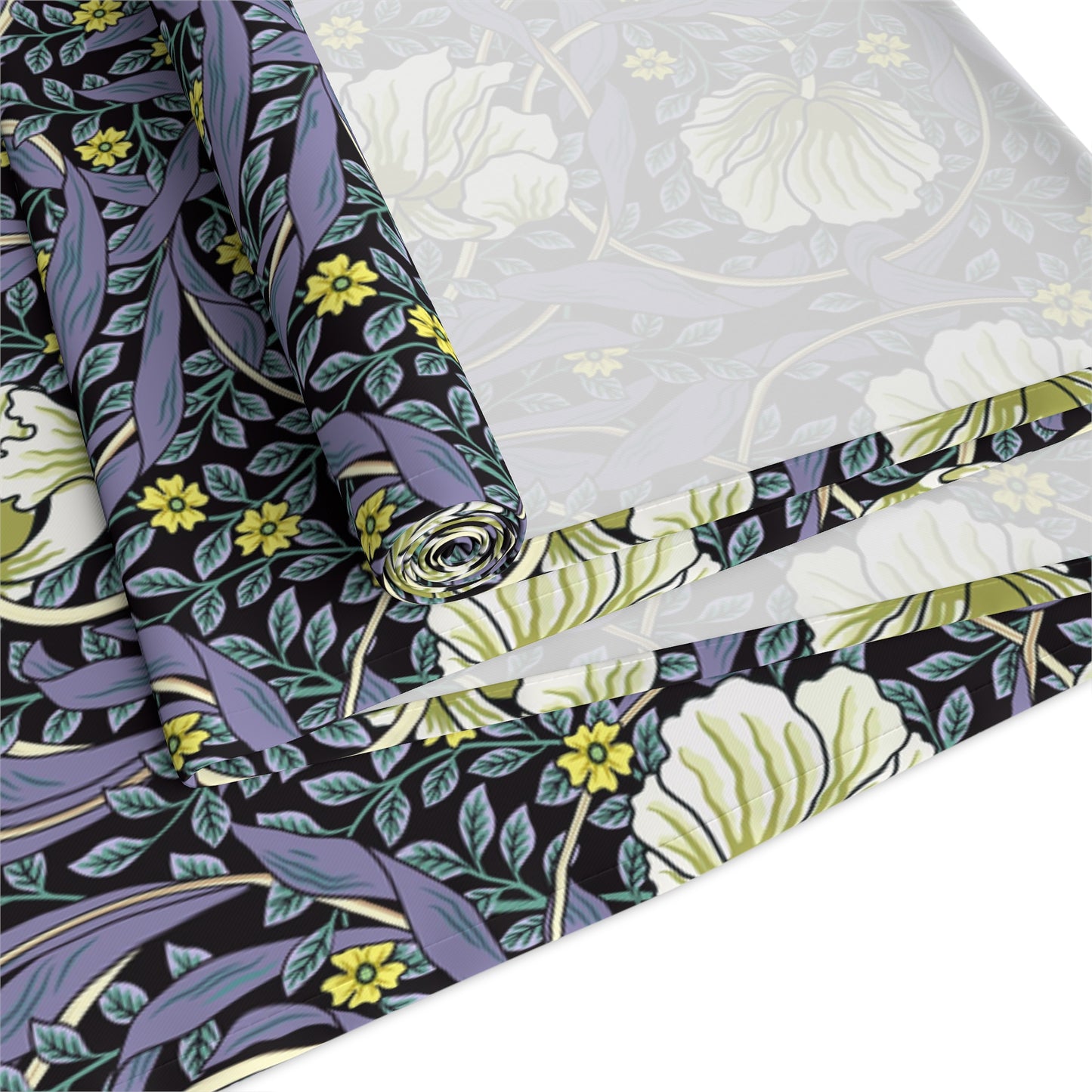 A table runner with a floral William Morris & Co pattern in shades of purple and green laid out on a dining table.