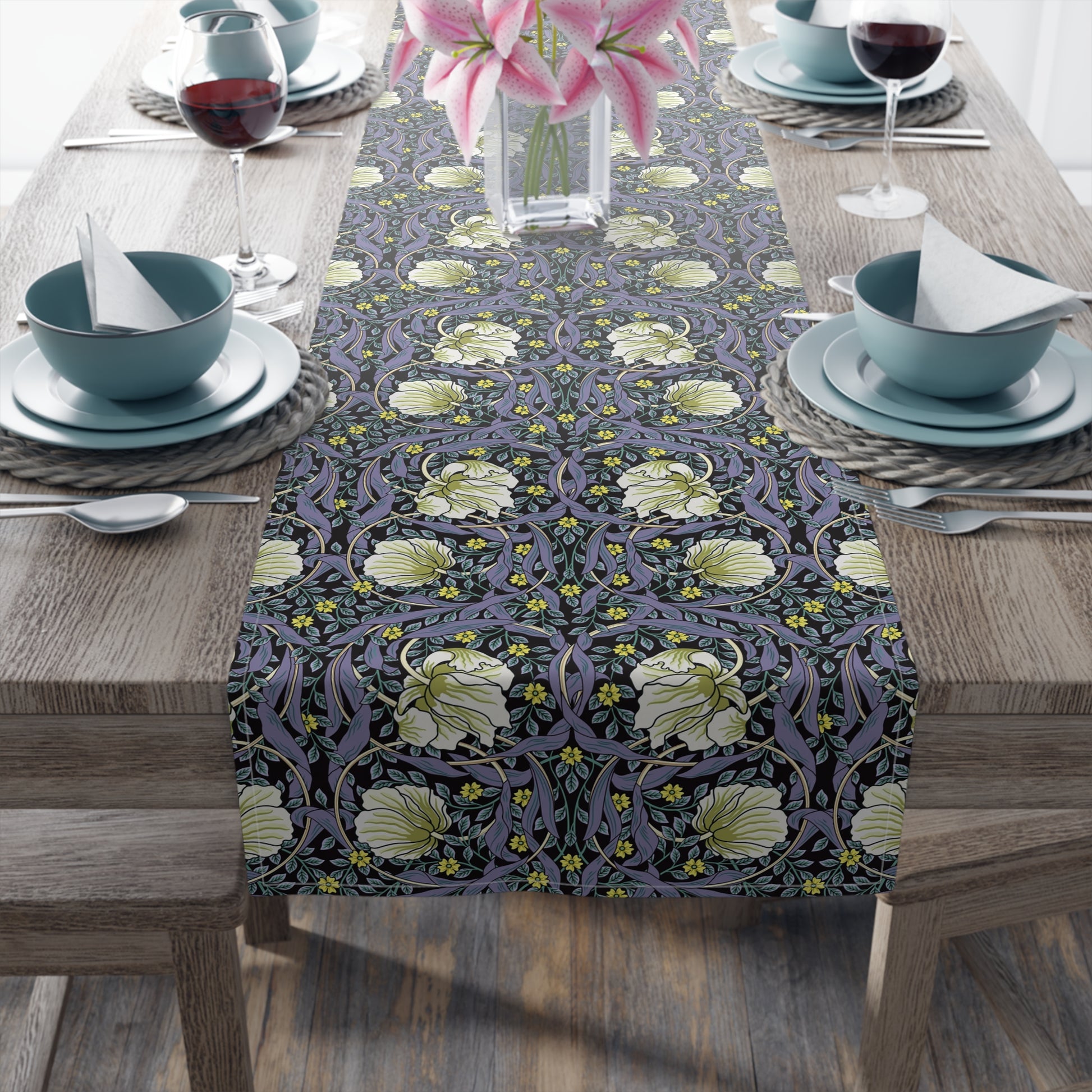 A table runner with a floral William Morris & Co pattern in shades of purple and green laid out on a dining table.