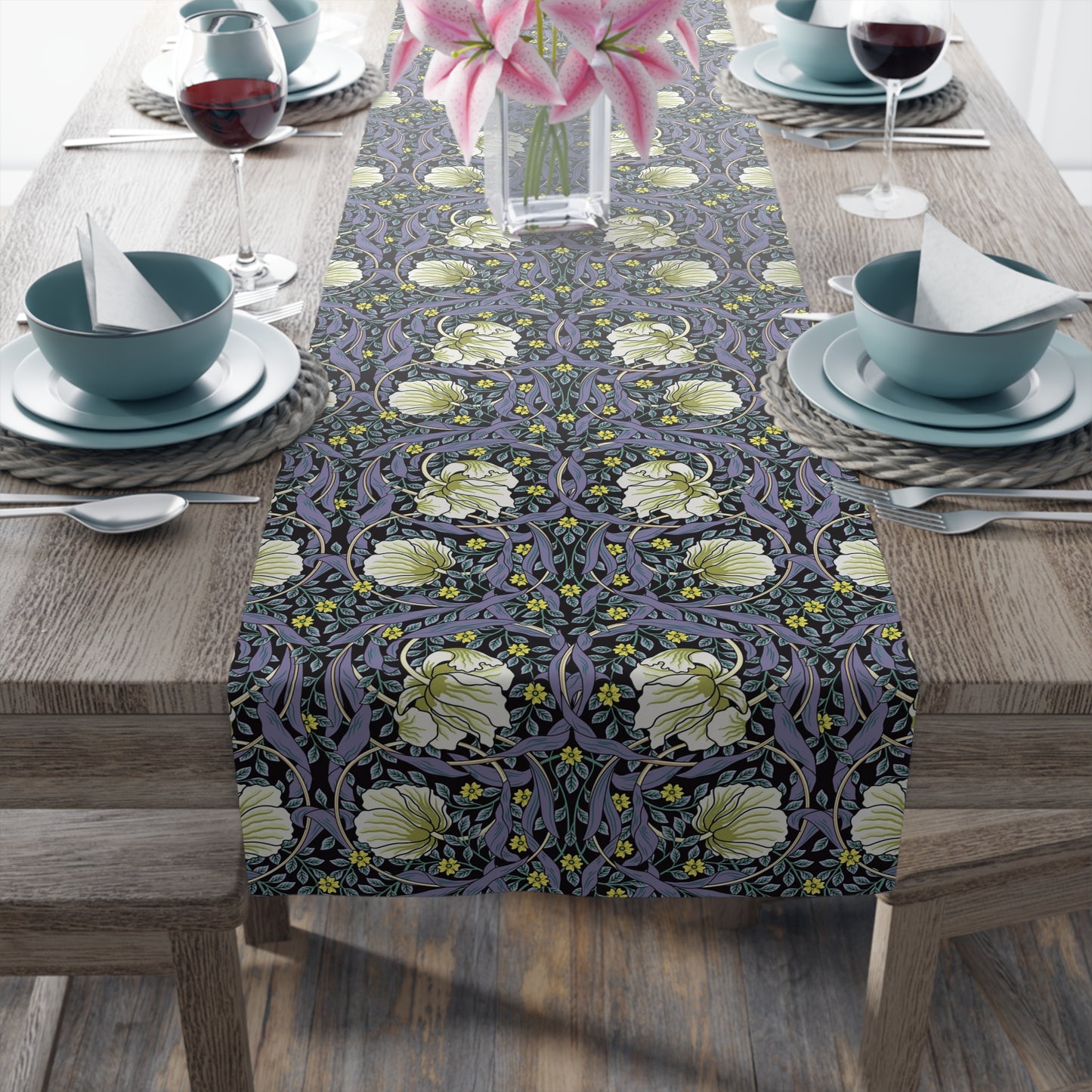 A table runner with a floral William Morris & Co pattern in shades of purple and green laid out on a dining table.
