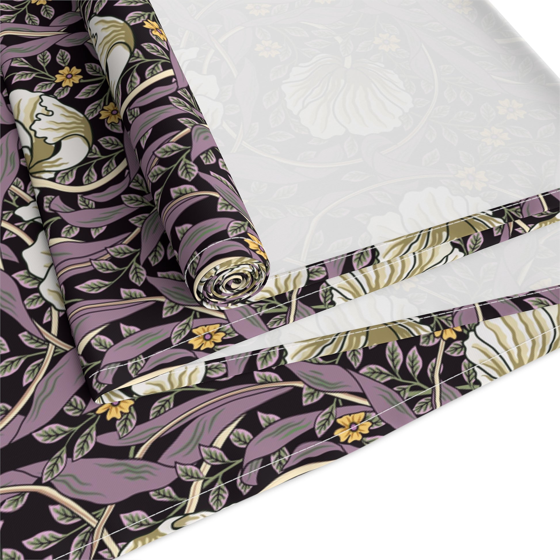 A table runner with a floral William Morris & Co pattern in purple, gold, and green colours, laid out on a dining table.