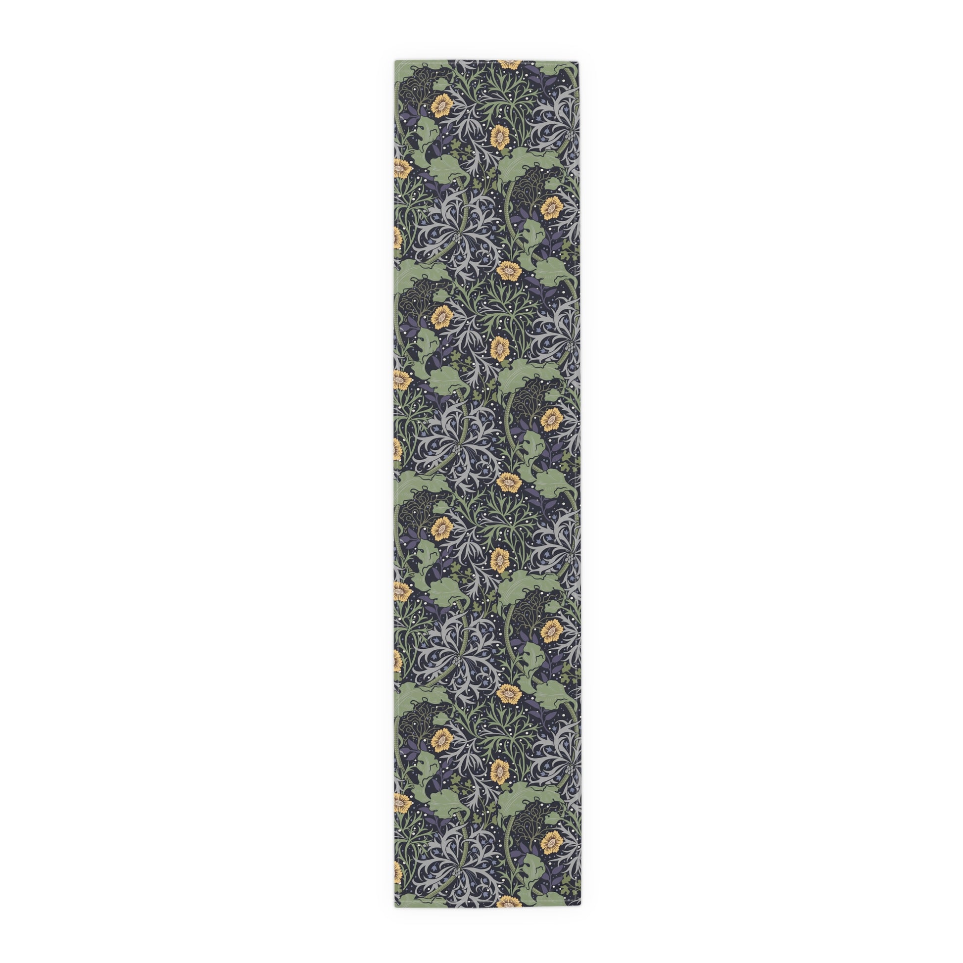 A table runner with a floral William Morris & Co pattern in yellow and green shades displayed on a dining table.