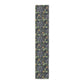 A table runner with a floral William Morris & Co pattern in yellow and green shades displayed on a dining table.