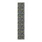 A table runner with a floral William Morris & Co pattern in yellow and green shades displayed on a dining table.