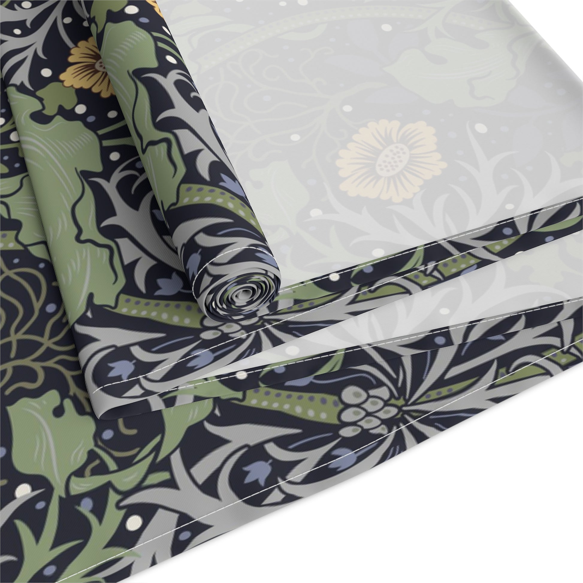 A table runner with a floral William Morris & Co pattern in yellow and green shades displayed on a dining table.