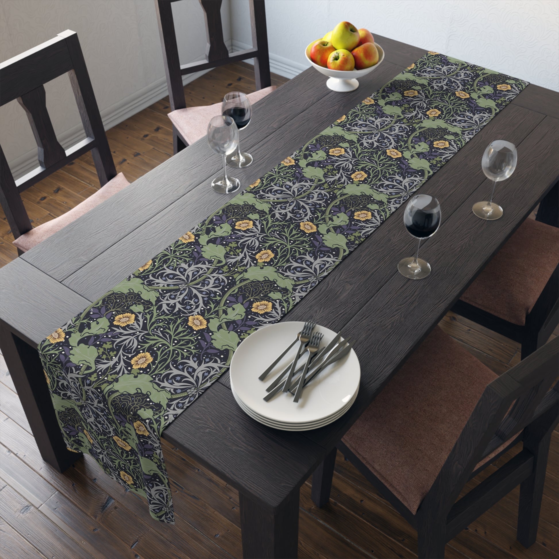A table runner with a floral William Morris & Co pattern in yellow and green shades displayed on a dining table.