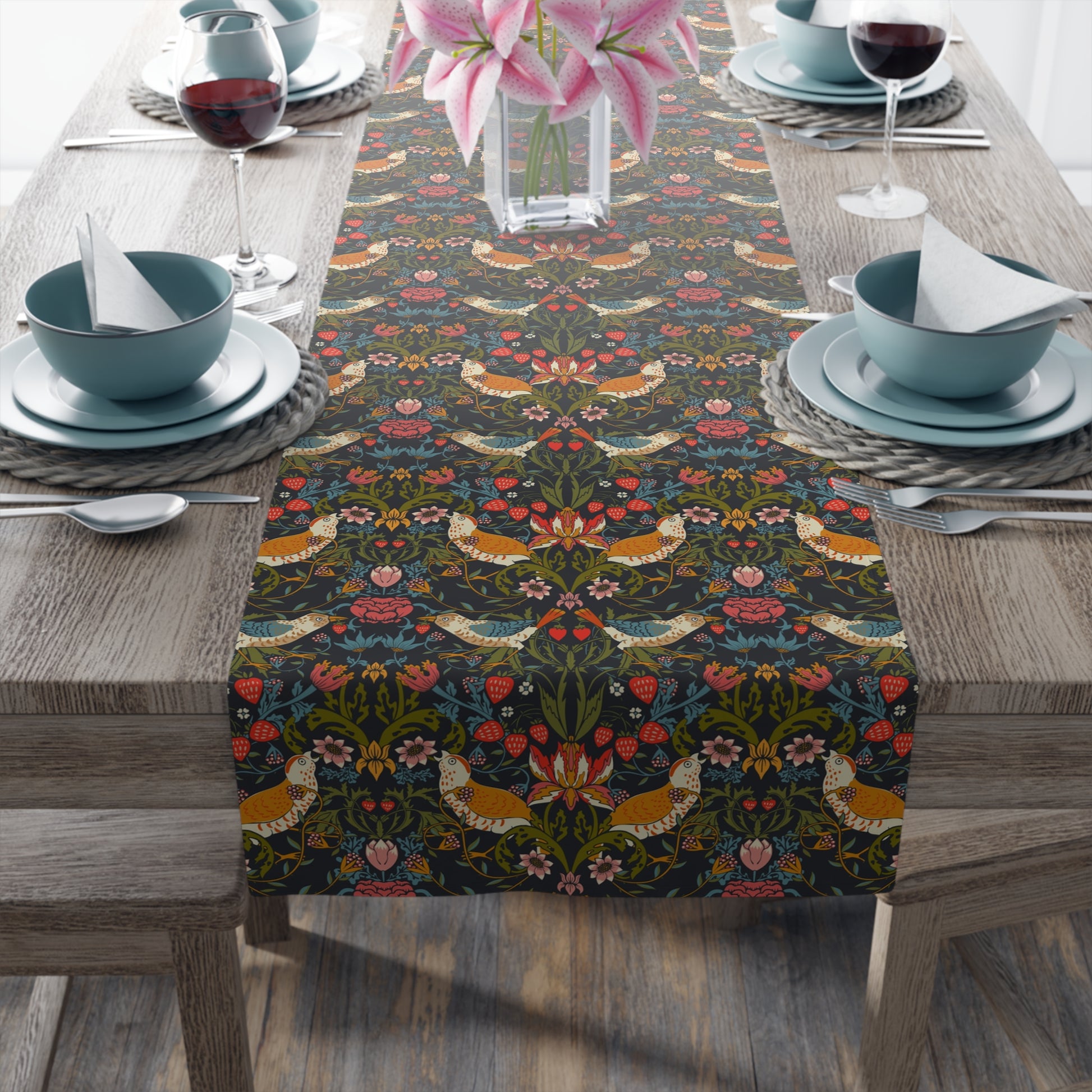 Table setting with a decorative table runner featuring floral and bird patterns.