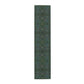 A green floral patterned table runner inspired by William Morris, laid out on a wooden dining table with plates and cutlery set on top.