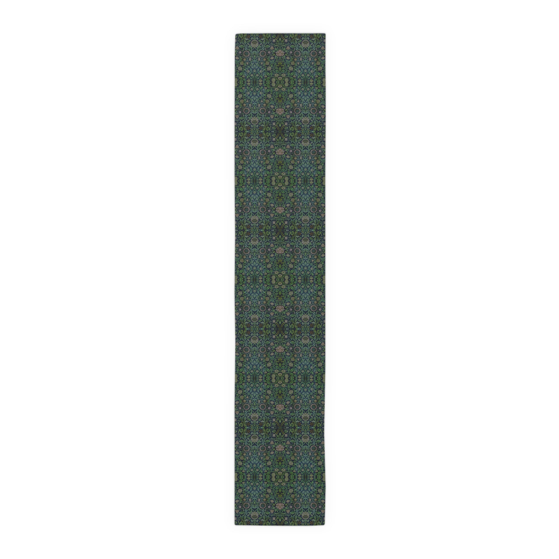 A green floral patterned table runner inspired by William Morris, laid out on a wooden dining table with plates and cutlery set on top.