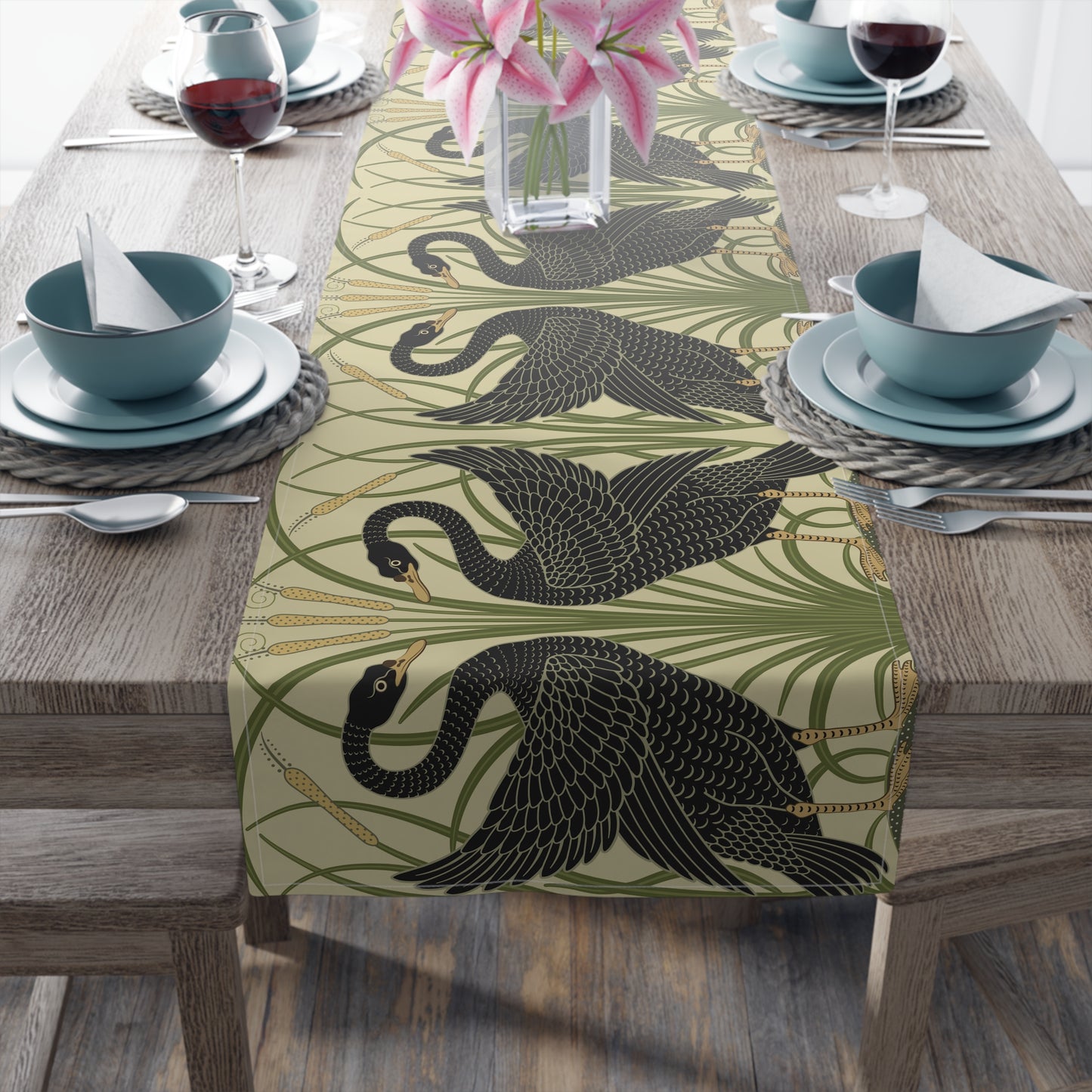 Table setting with a decorative table runner inspired by William Morris & Co featuring black swans on a tan coloured background.