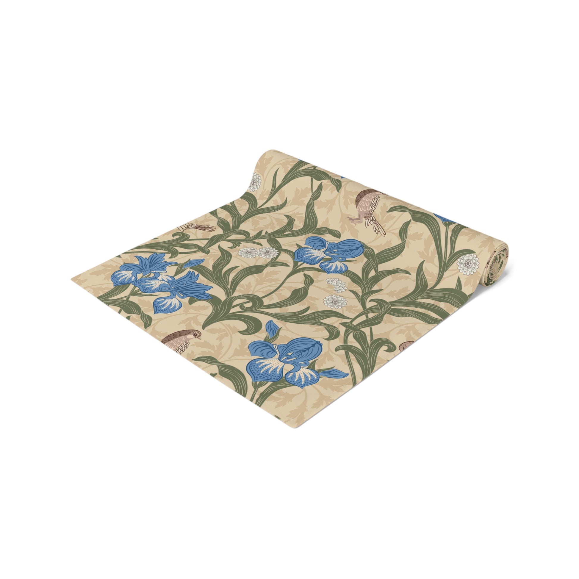 A table runner with a Victorian floral design in blue and green on a beige background, laid out on a dining table with place settings and decorative flowers.