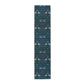 A William Morris & Co table runner with a bluebird design laid out on a dining table, featuring a repeating pattern with birds and foliage.