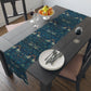 A William Morris & Co table runner with a bluebird design laid out on a dining table, featuring a repeating pattern with birds and foliage.
