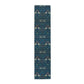 A William Morris & Co table runner with a bluebird design laid out on a dining table, featuring a repeating pattern with birds and foliage.