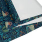 A William Morris & Co table runner with a bluebird design laid out on a dining table, featuring a repeating pattern with birds and foliage.
