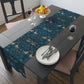 A William Morris & Co table runner with a bluebird design laid out on a dining table, featuring a repeating pattern with birds and foliage.