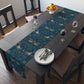 A William Morris & Co table runner with a bluebird design laid out on a dining table, featuring a repeating pattern with birds and foliage.