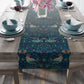 A William Morris & Co table runner with a bluebird design laid out on a dining table, featuring a repeating pattern with birds and foliage.
