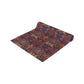 A multicolored table runner with a floral and William Morris & Co animal pattern displayed on a dining table.