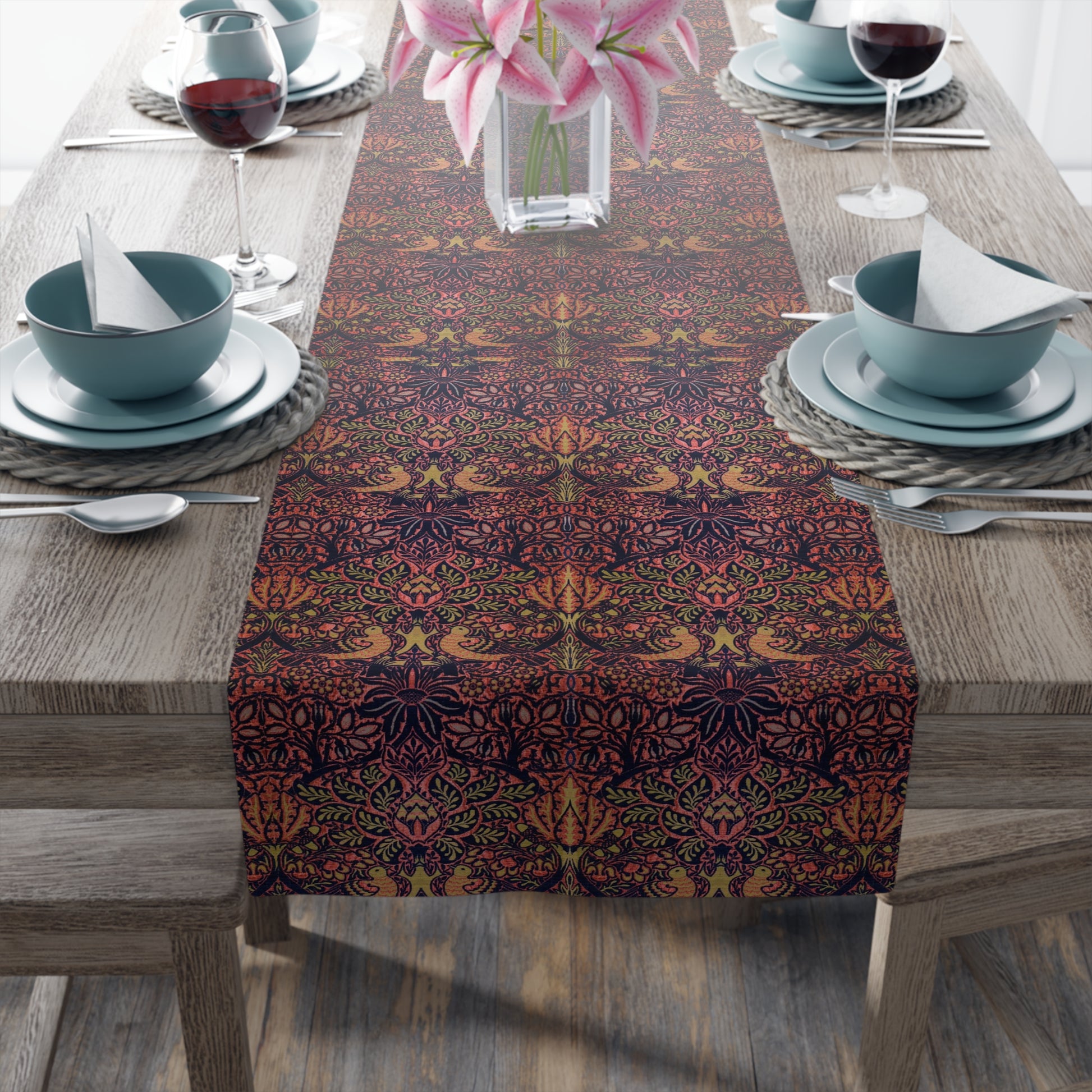 A multicolored table runner with a floral and animal pattern displayed on a dining table.