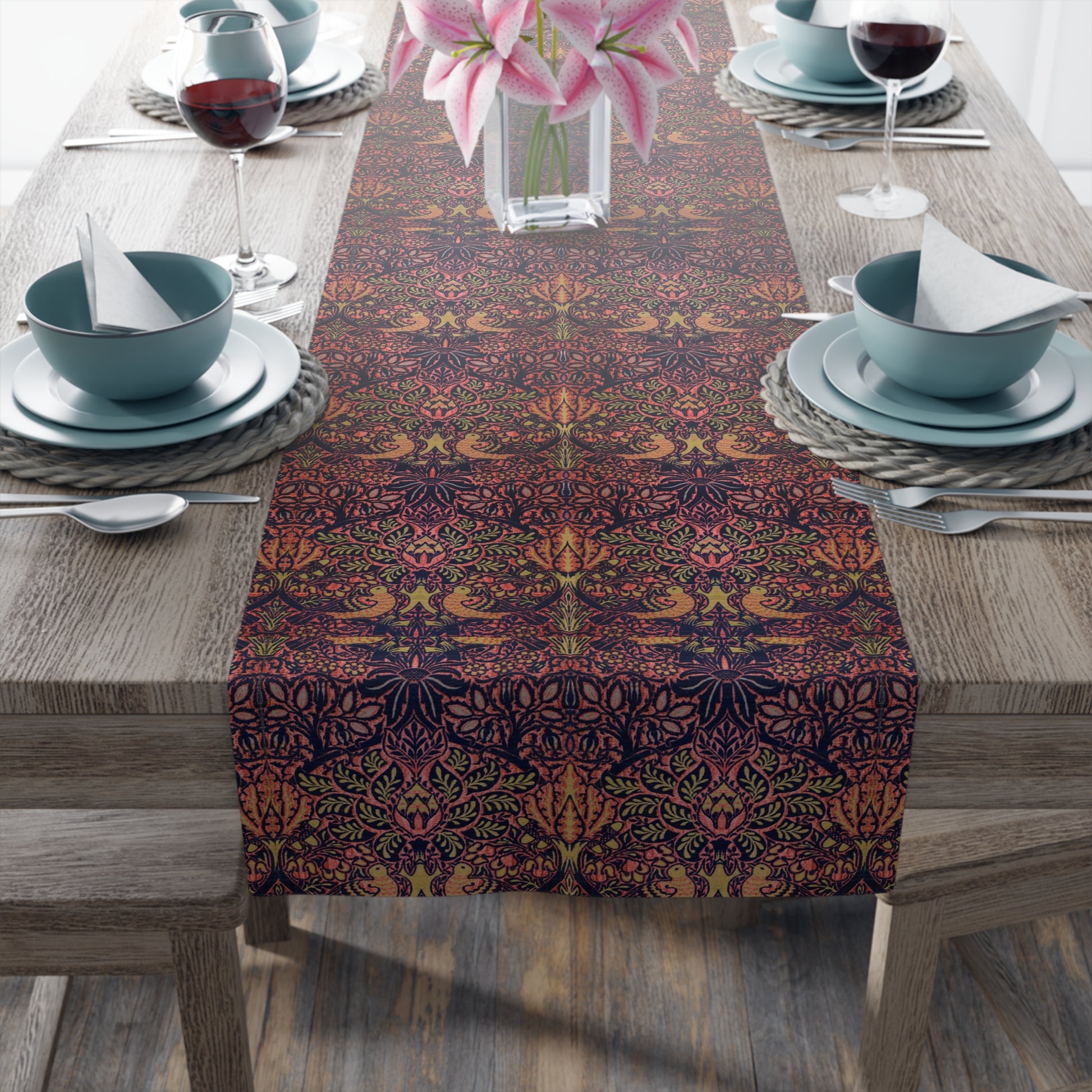 A multicolored table runner with a floral and animal pattern displayed on a dining table.