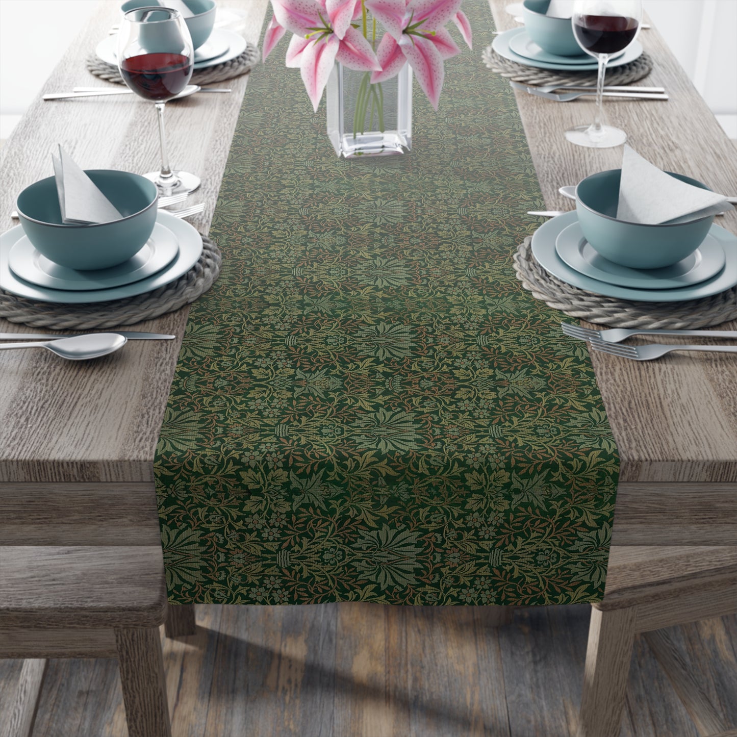A green table runner with a floral William Morris & Co pattern displayed on a dining table.