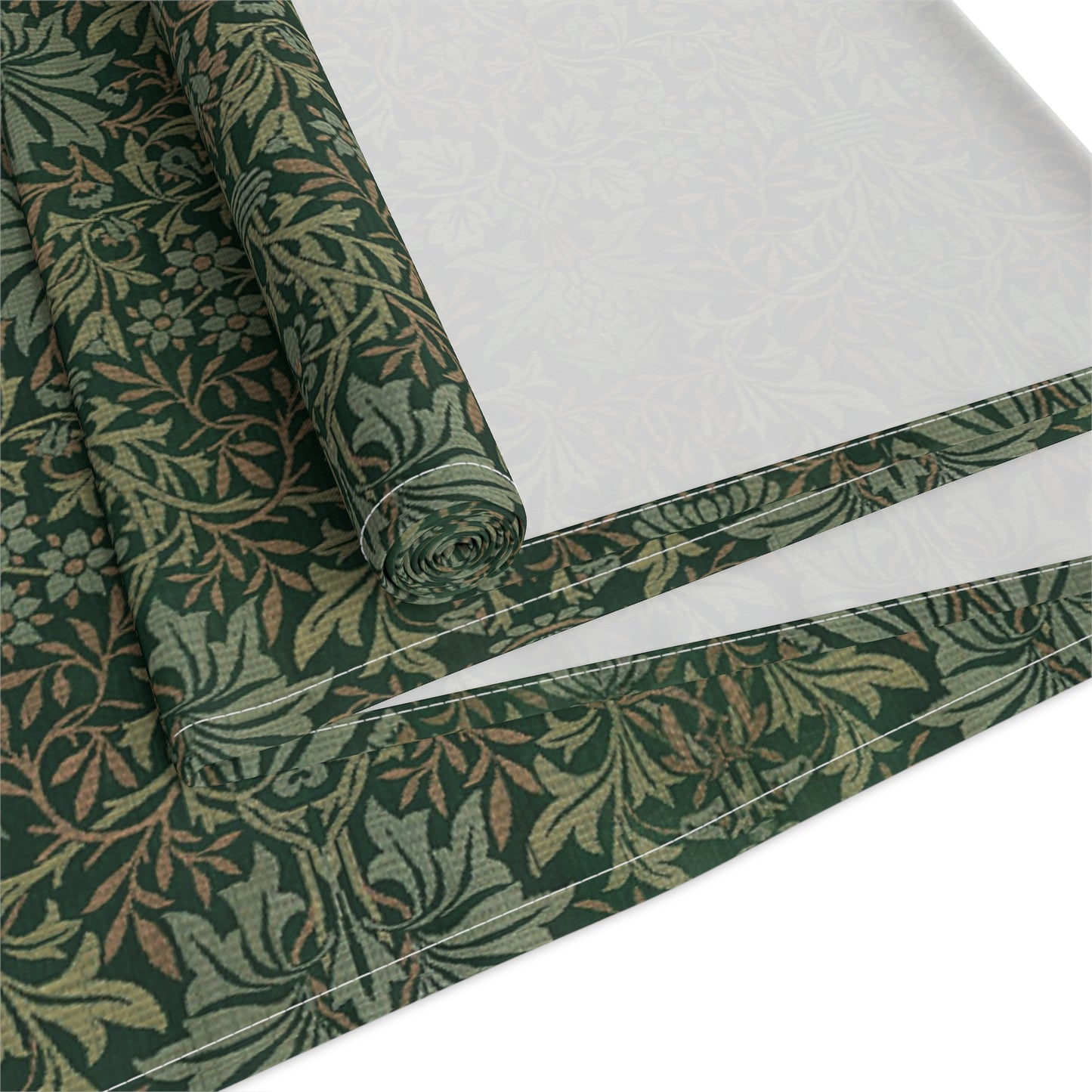 A green table runner with a floral William Morris & Co pattern displayed on a dining table.