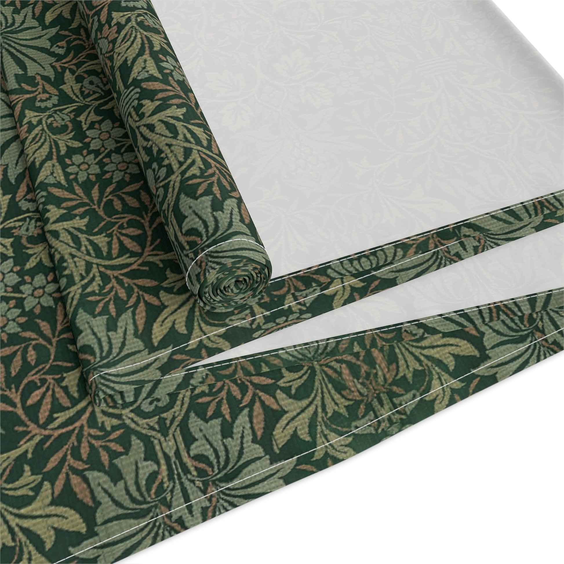 A green table runner with a floral William Morris & Co pattern displayed on a dining table.