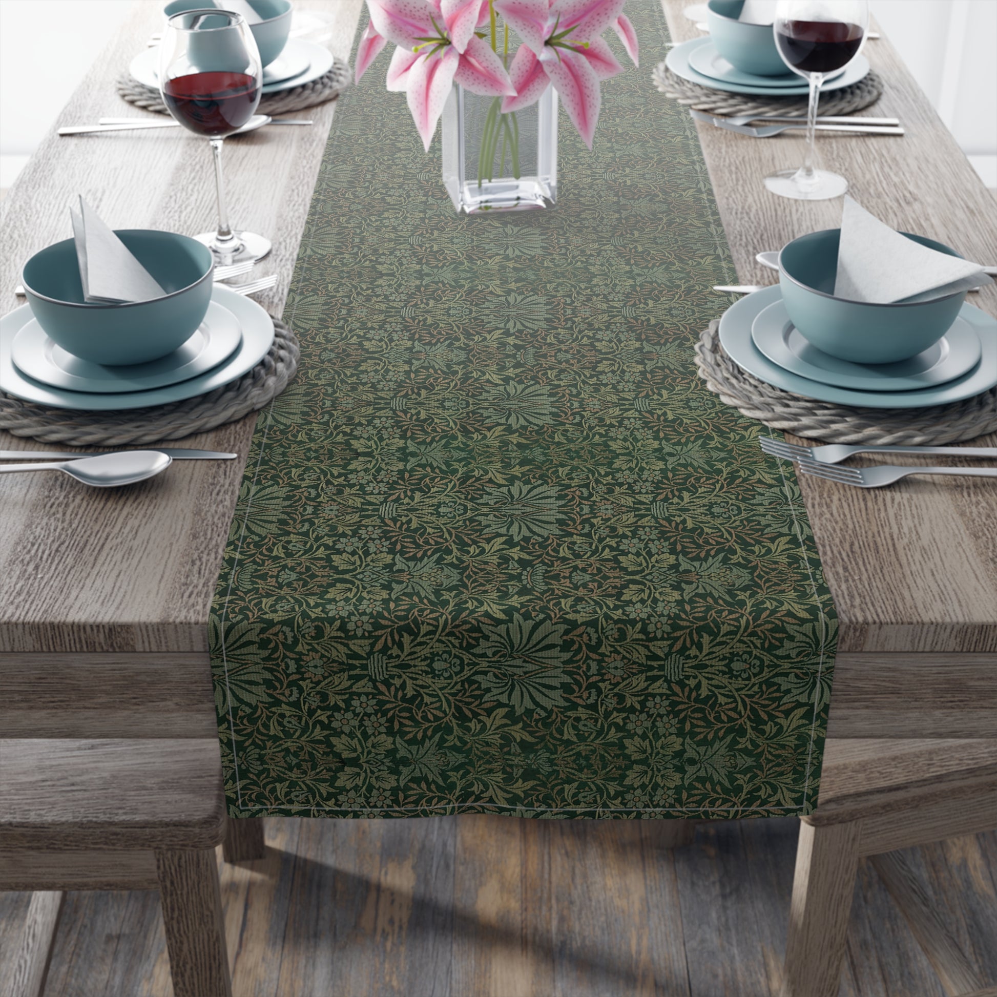 A green table runner with a floral William Morris & Co pattern displayed on a dining table.