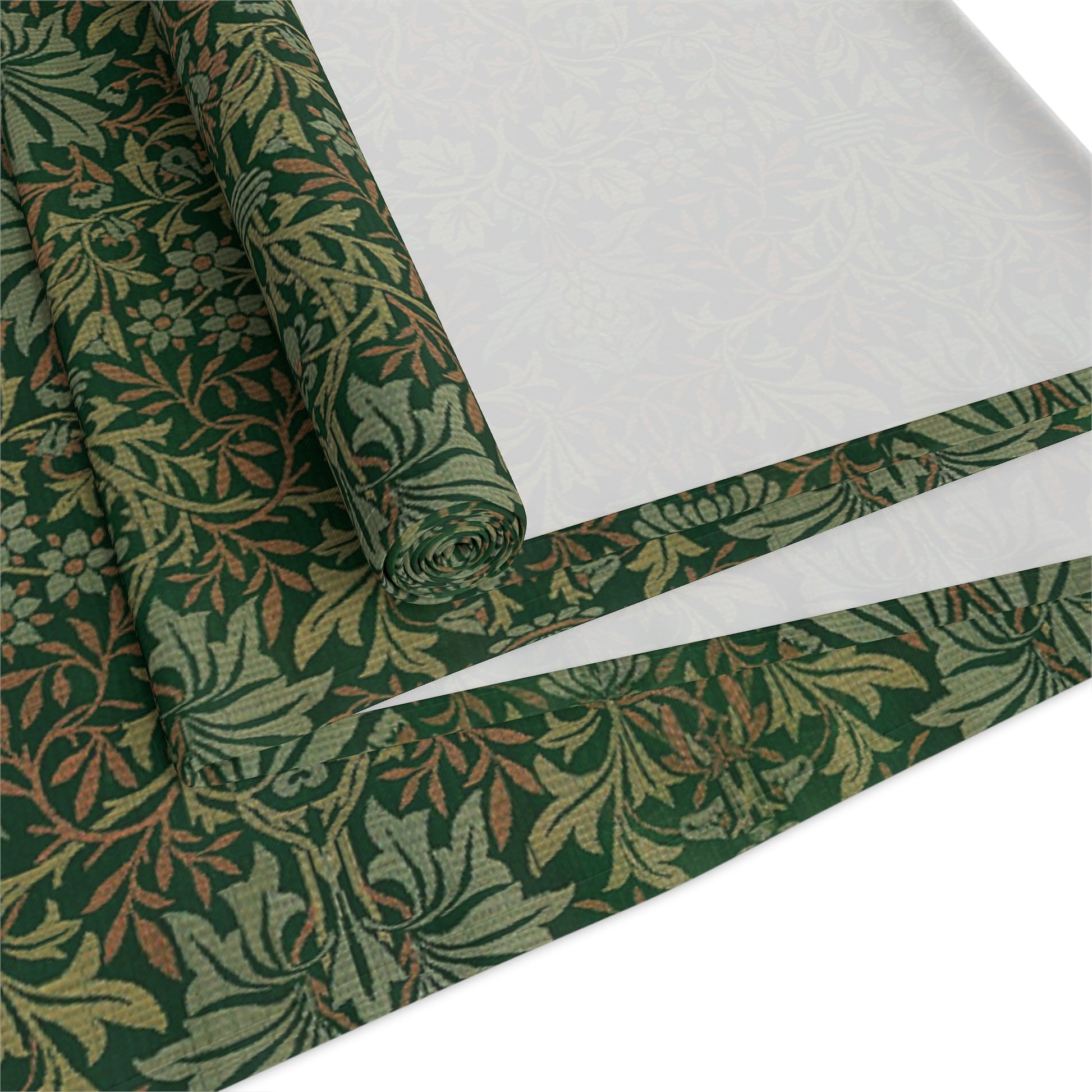 A green table runner with a floral William Morris & Co pattern displayed on a dining table.