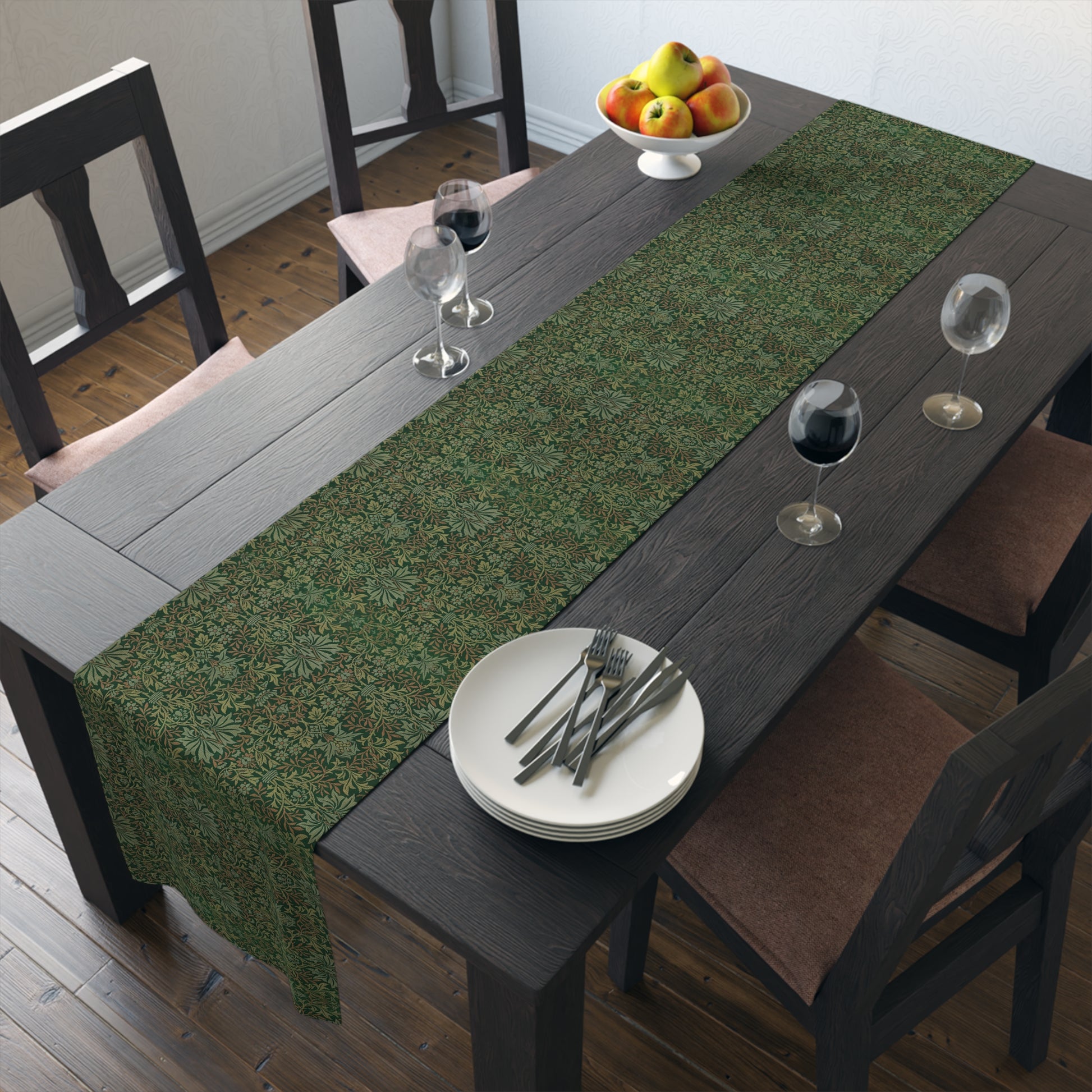 A green table runner with a floral William Morris & Co pattern displayed on a dining table.