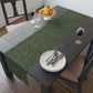 A green table runner with a floral William Morris & Co pattern displayed on a dining table.